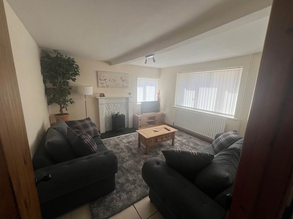A living room with a sofa, television, and fireplace at Blyton 2-Bed Cottage, Parking, 30m to Lincoln, Gainsborough
