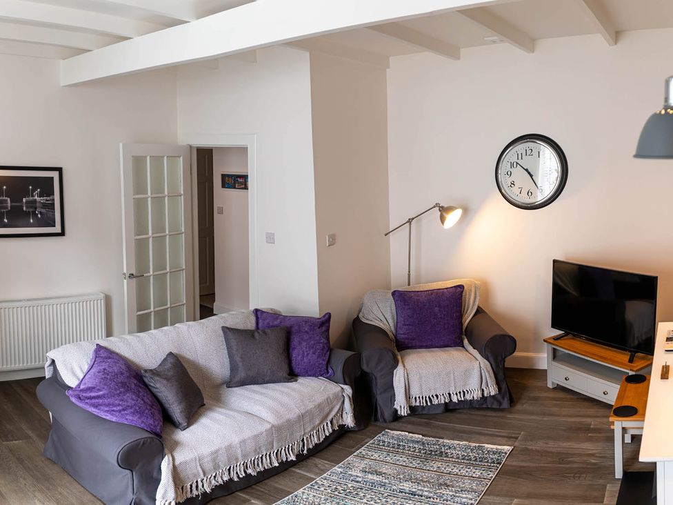 A living room with a sofa and television at The Old Paint Shop Apartment - Centrally Situated Anstruther
