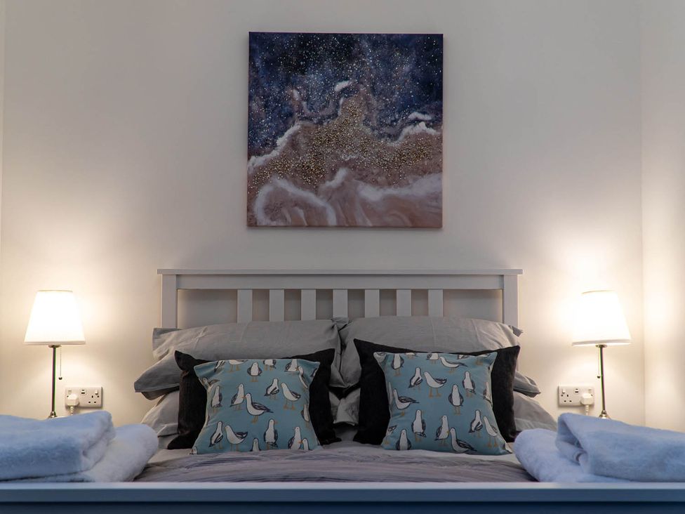 A bedroom with a bed and pillows at The Old Paint Shop Apartment - Centrally Situated Anstruther