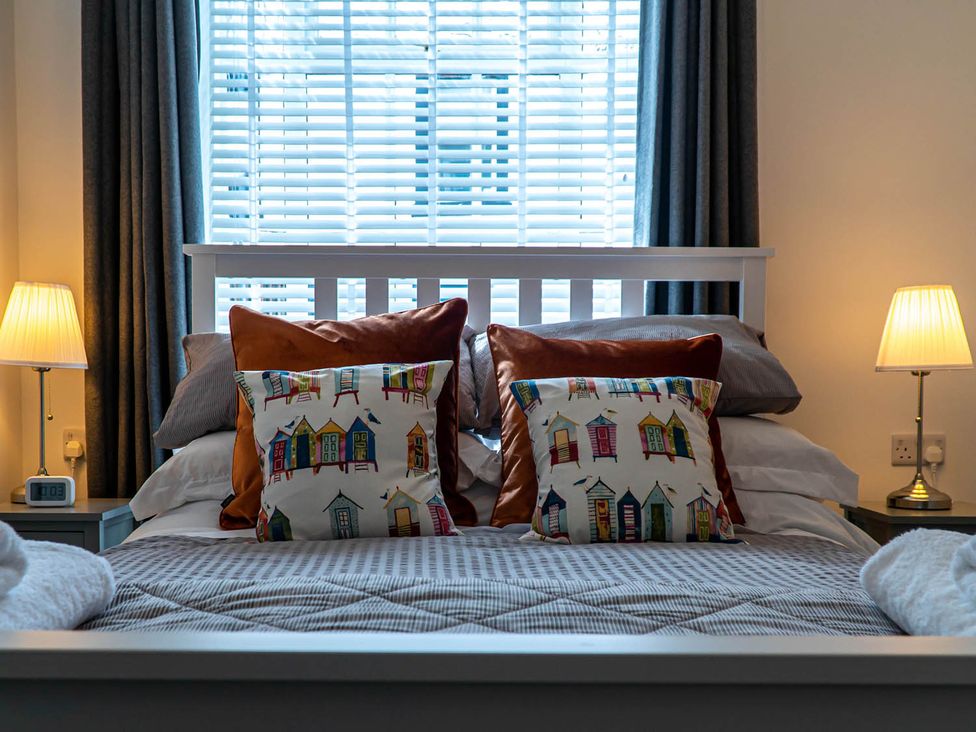 A bedroom with a bed and bedside lamps at The Old Paint Shop Apartment - Centrally Situated in Anstruther