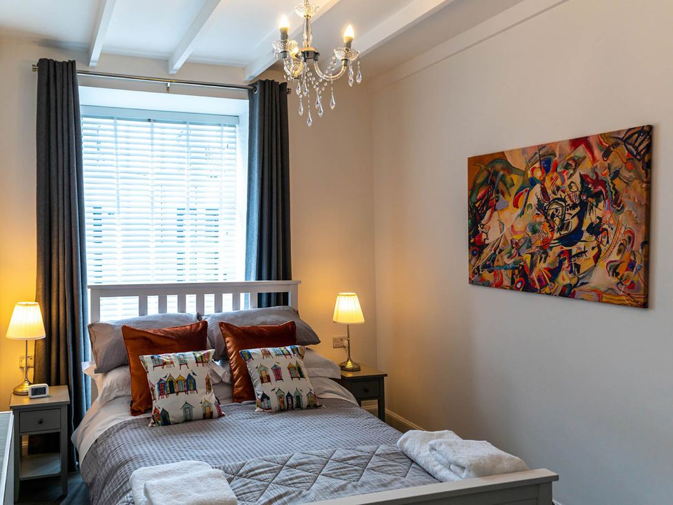 A bedroom with a bed and wall art at The Old Paint Shop Apartment - Centrally Situated Anstruther