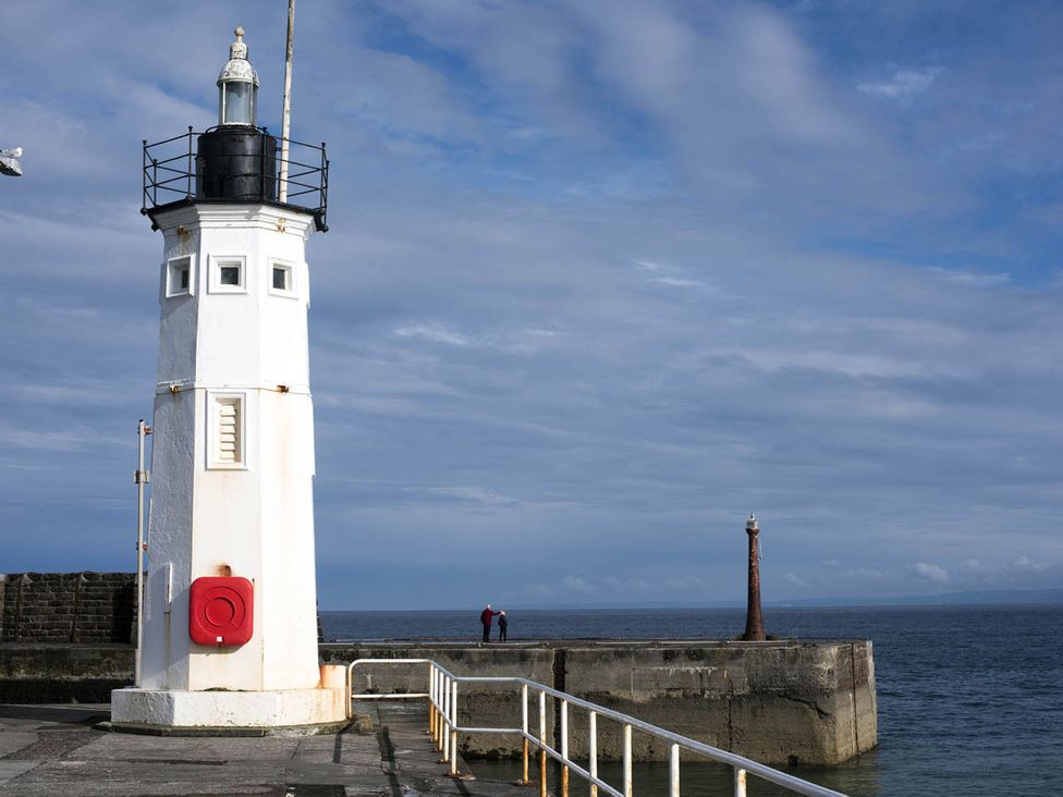 A lighthouse and pier by the ocean at The Old Paint Shop Apartment - Centrally Situated in Anstruther