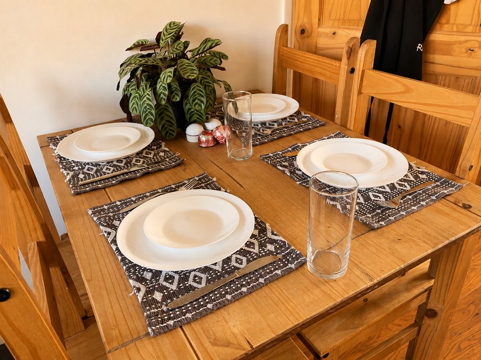 A dining table set with plates and glasses at Family Friendly Coach House - Parking - Sleeps 4 in Ebdon