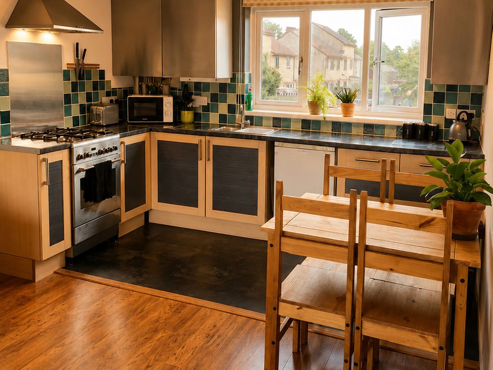 A kitchen with an oven, sink, and dining table at Family Friendly Coach House - Parking - Sleeps 4 in Ebdon