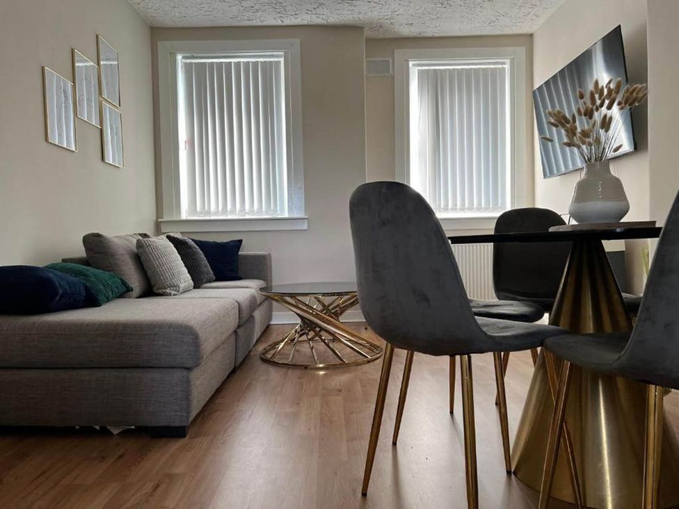 A living room with a sofa, table, and chairs at 3 Bedroom Flat, sleeping 6 with free parking, Kirkcaldy