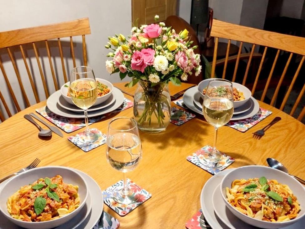 A dining table set with pasta dishes and drinks at 2 Bed cottage, pets welcome and parking available, Uffington