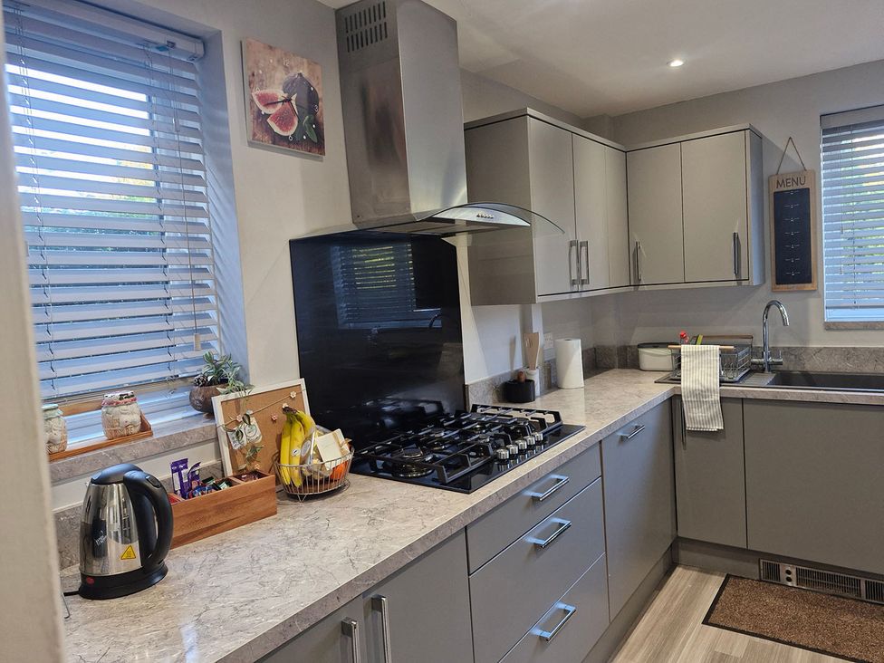A kitchen with modern cabinets and appliances at 3 Bedroom, sleeping 5 with Wifi Wythenshawe near Manchester