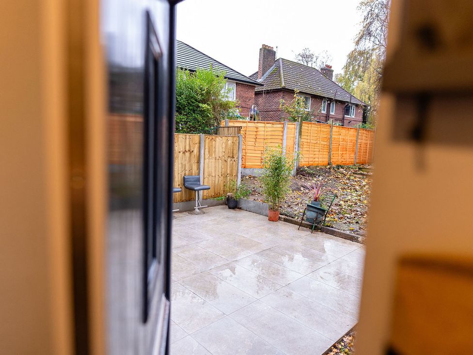A garden with a patio area and potted plants at 3 Bedroom, sleeping 5 with Wifi in Wythenshawe near Manchester