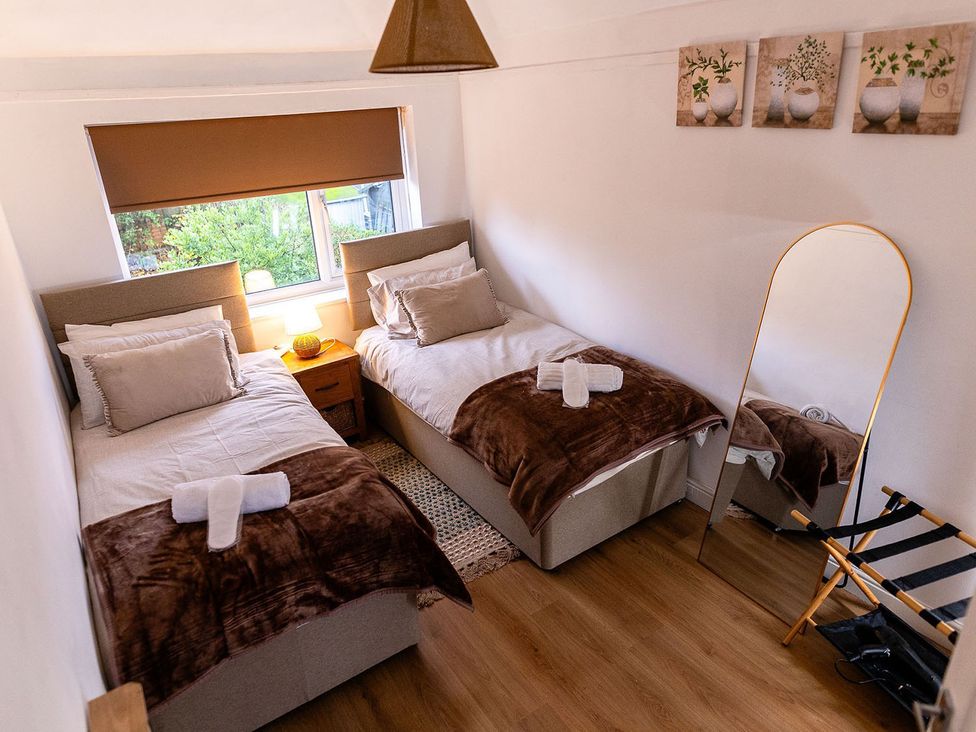 A bedroom with twin beds and a mirror at 3 Bedroom, sleeping 5 with Wifi in Wythenshawe near Manchester