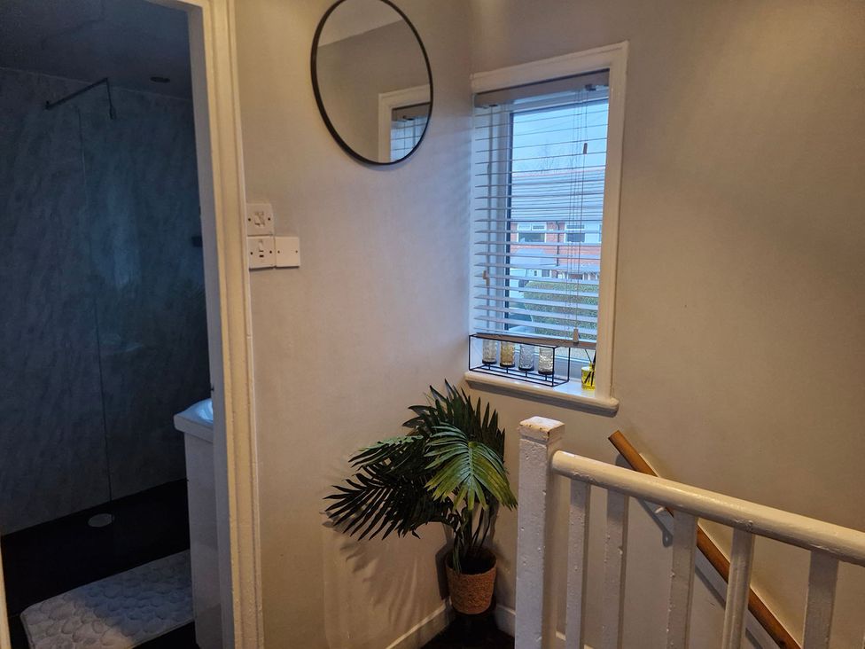 A hallway with a mirror and a plant at 3 Bedroom, sleeping 5 with Wifi in Wythenshawe near Manchester