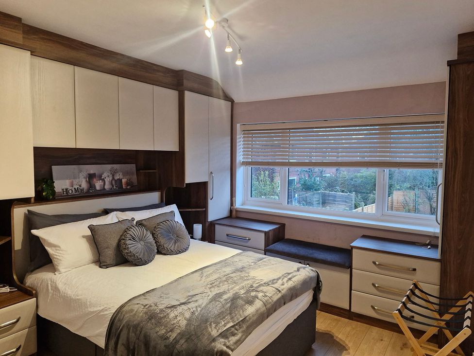 A bedroom with a bed and storage cabinets at 3 Bedroom, sleeping 5 with Wifi, Wythenshawe near Manchester