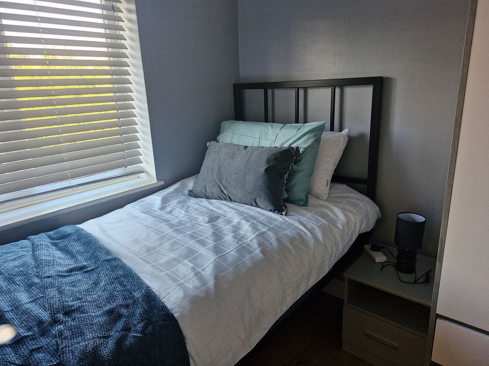 A bedroom with a bed and nightstand at 3 Bedroom, sleeping 5 with Wifi Wythenshawe near Manchester
