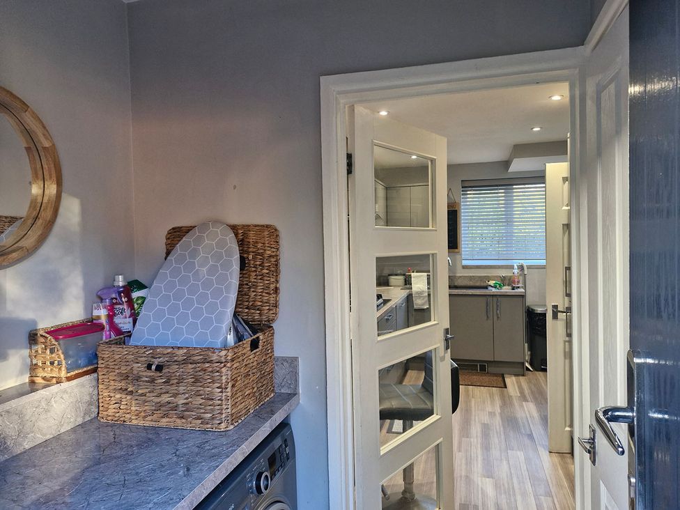 A laundry room with a basket and ironing board at 3 Bedroom, sleeping 5 with Wifi Wythenshawe near Manchester