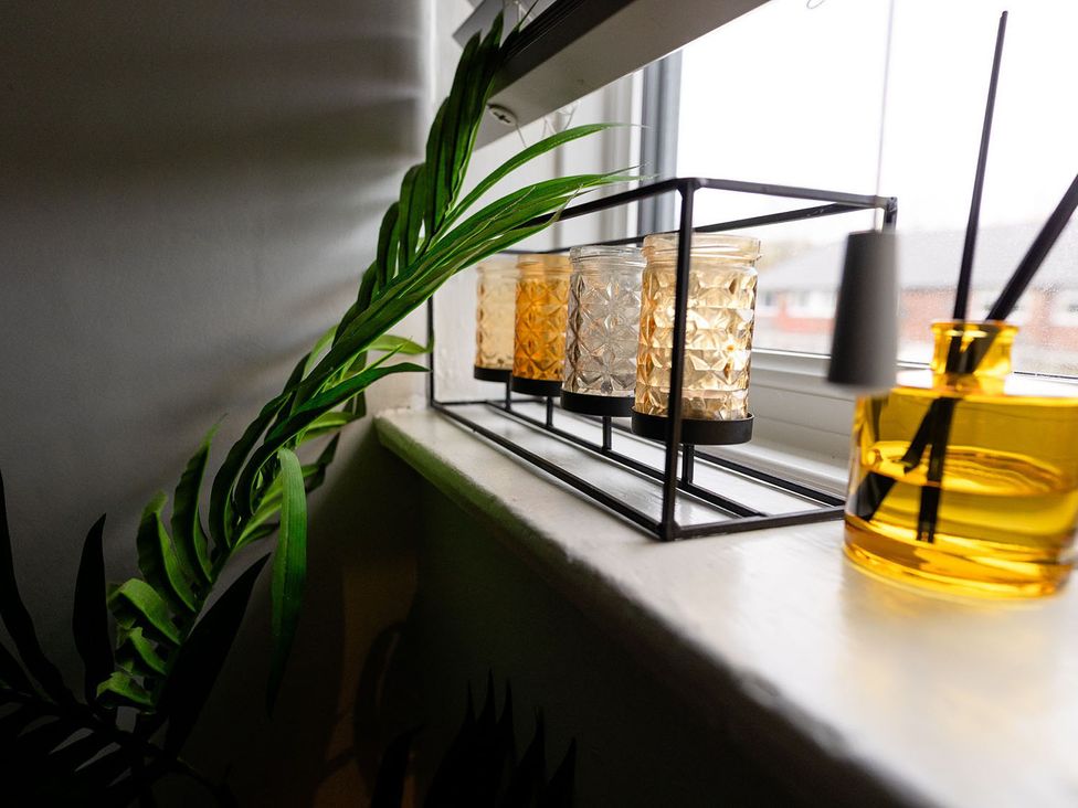 A living room with candles and a diffuser on a windowsill at 3 Bedroom, sleeping 5 with Wifi, Wythenshawe near Manchester
