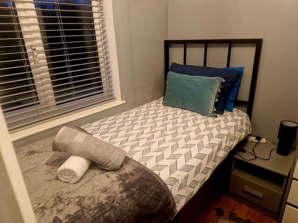 A bedroom with a bed and nightstand at 3 Bedroom, sleeping 5 with Wifi Wythenshawe near Manchester