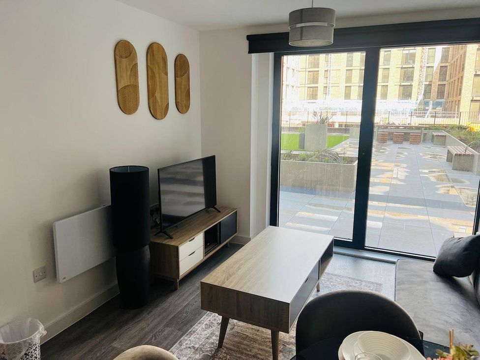 A living room with a television and coffee table at Apartment near Old Trafford, Sleeping 3 with Garden and Parking, Manchester