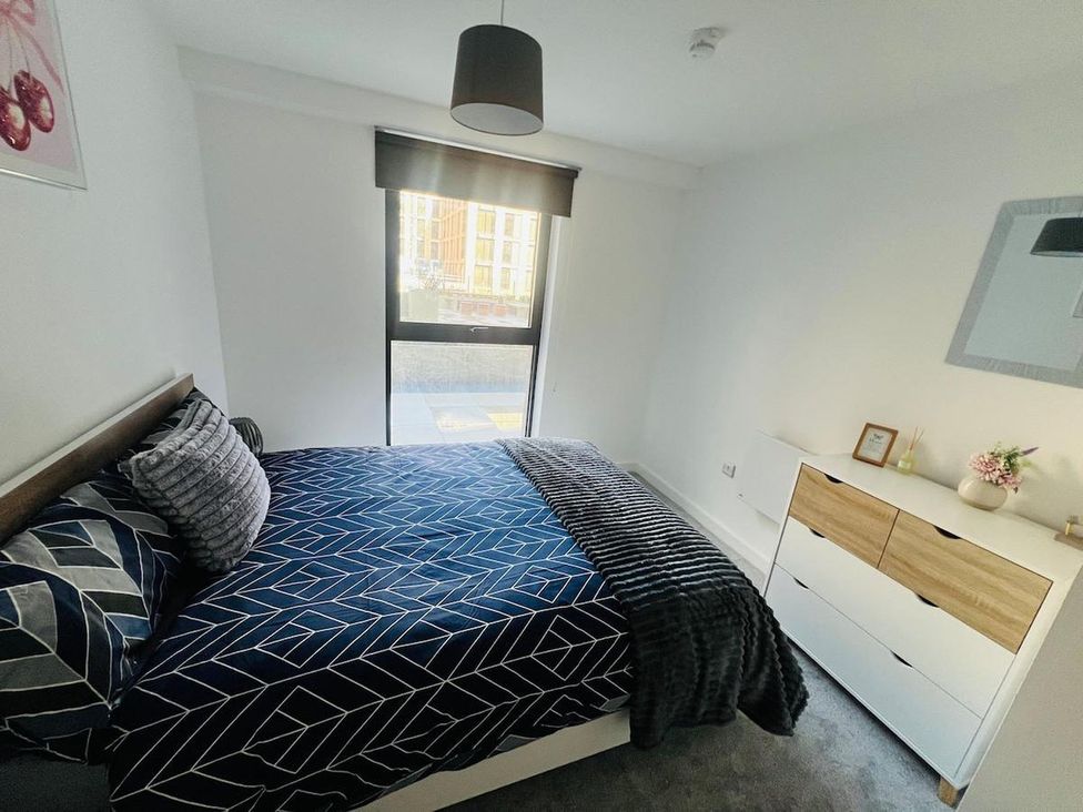 A bedroom with a bed and dresser at Apartment near Old Trafford, Sleeping 3 with Garden and Parking in Manchester