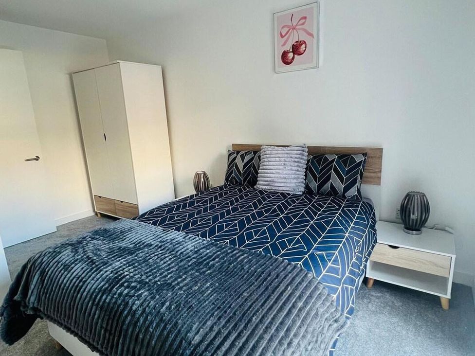 A bedroom with a bed and nightstand at Apartment near Old Trafford, Sleeping 3 with Garden and Parking, Manchester