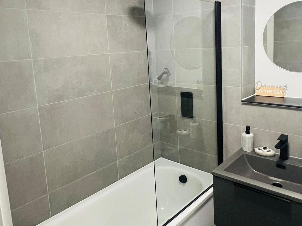 A bathroom with a bathtub and sink at Apartment near Old Trafford, Sleeping 3 with Garden and Parking in Manchester
