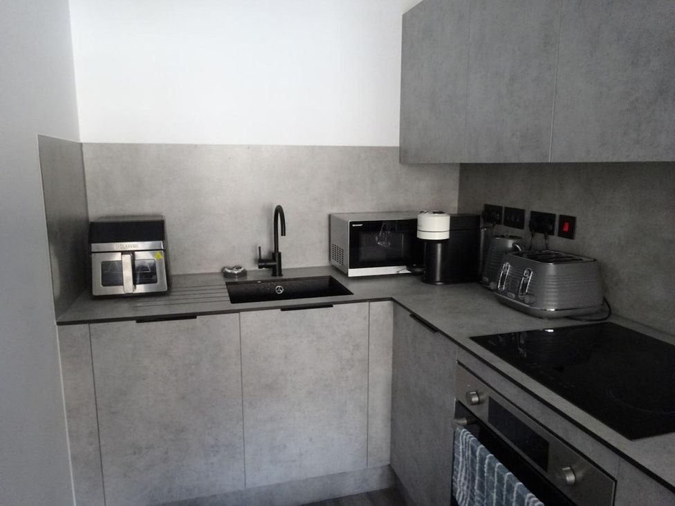 A kitchen with appliances including a microwave, sink, and toaster at Apartment near Old Trafford, Sleeping 3 with Garden and Parking, Manchester