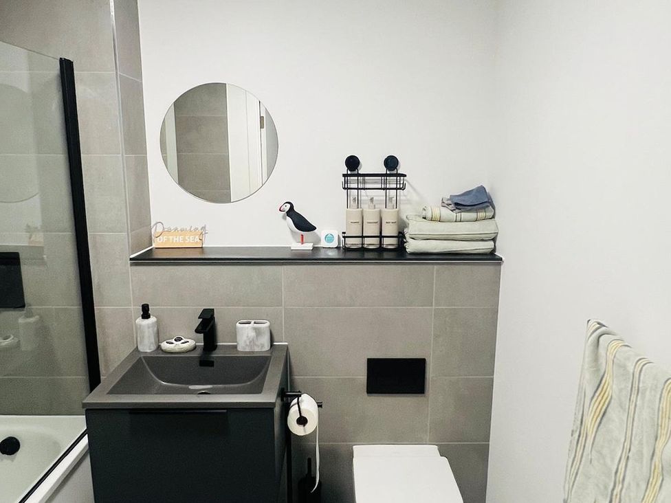 A bathroom with a sink, toilet, and mirror at Apartment near Old Trafford, Sleeping 3 with Garden and Parking Manchester