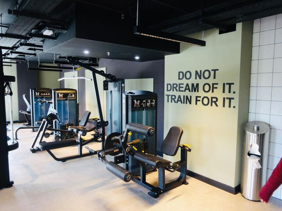A gym with exercise machines and motivational wall art at Apartment near Old Trafford, Sleeping 3 with Garden and Parking, Manchester