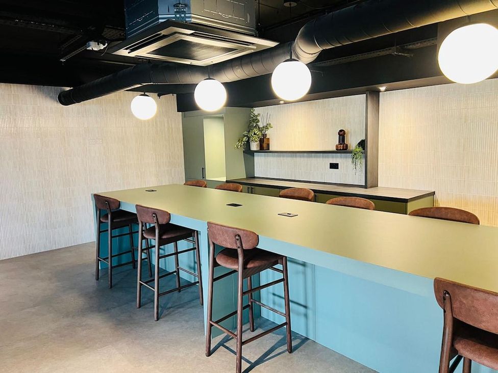A kitchen with a bar counter and stools at Apartment near Old Trafford, Sleeping 3 with Garden and Parking, Manchester
