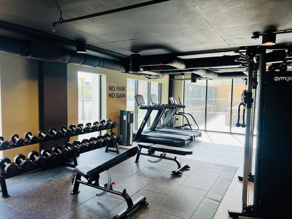 A gym with dumbbells and exercise equipment at Apartment near Old Trafford, Sleeping 3 with Garden and Parking Manchester
