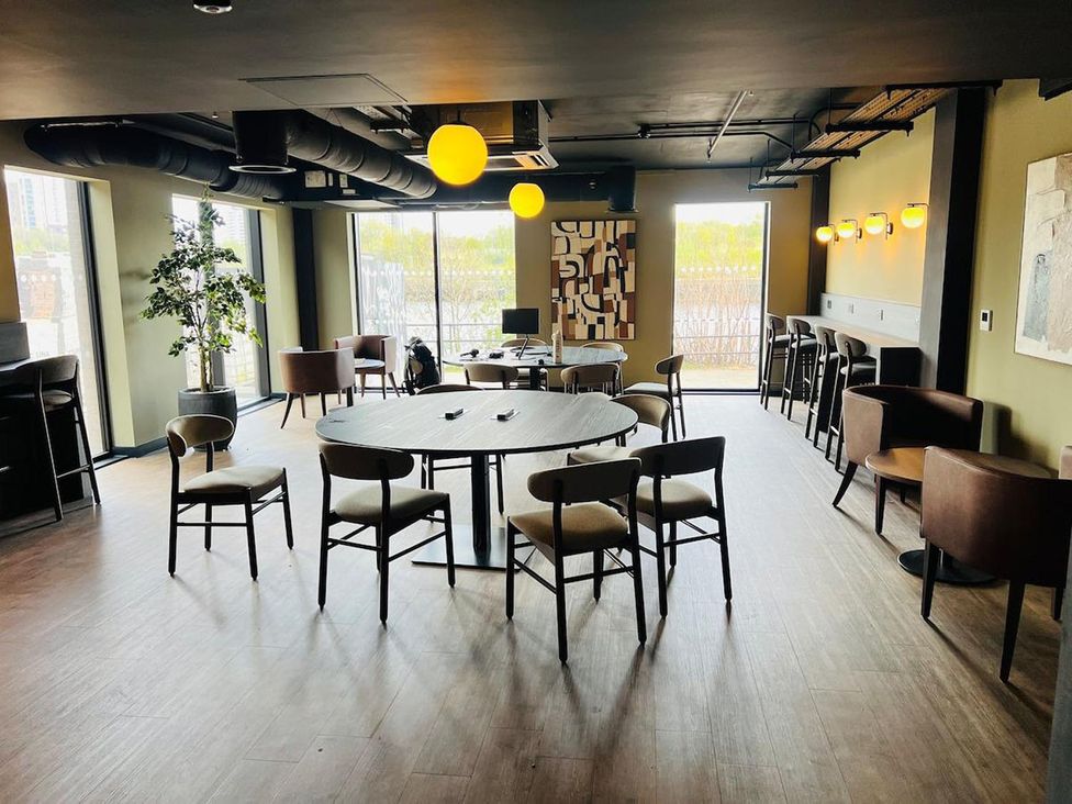 A lounge area with tables and chairs at Apartment near Old Trafford, Sleeping 3 with Garden and Parking, Manchester