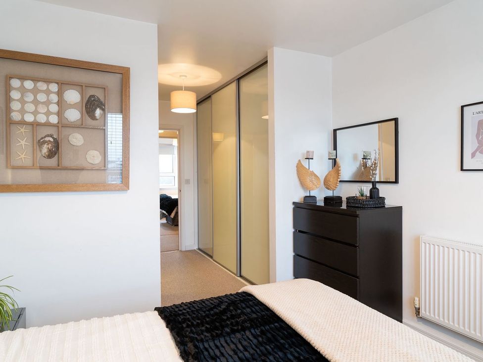 A bedroom with a bed and a dressing table at Apartment, Sleeps 6 with Stadium View in Manchester