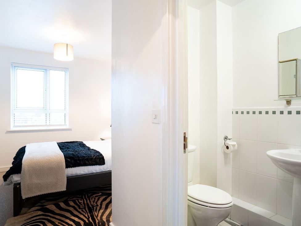 A bedroom featuring a bed and an adjoining bathroom at Apartment, Sleeps 6 with Stadium View Manchester
