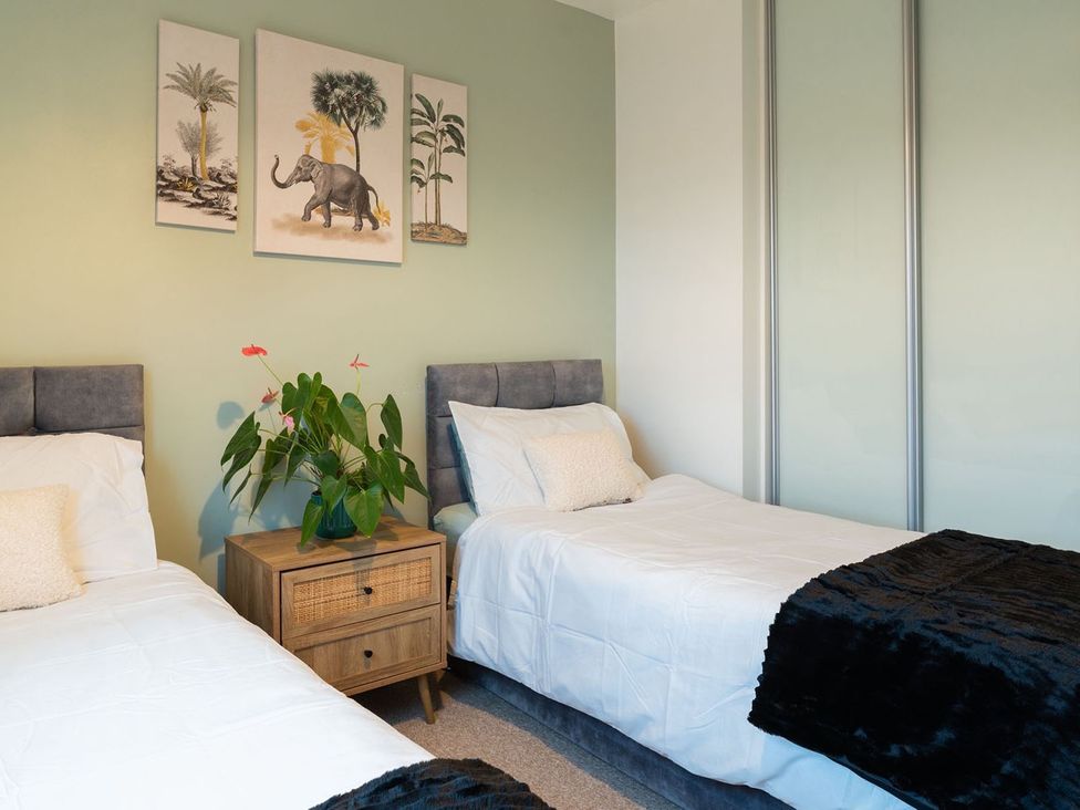 A bedroom with twin beds and a nightstand at Apartment, Sleeps 6 with Stadium View in Manchester