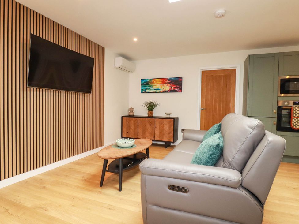 A living room with a sofa and television at Rule retreat in Penzance