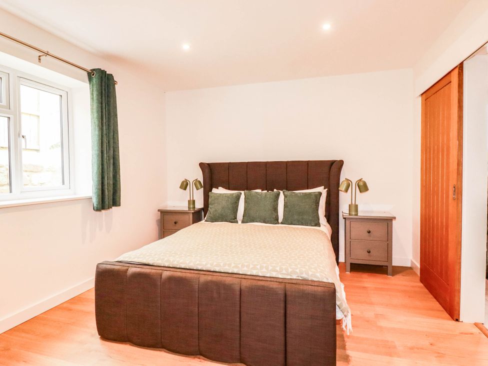 A bedroom featuring a bed and bedside tables at Rule retreat in Penzance