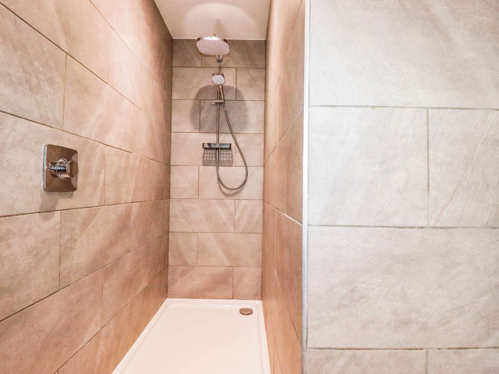 A shower with tiles and controls at Rule retreat in Penzance