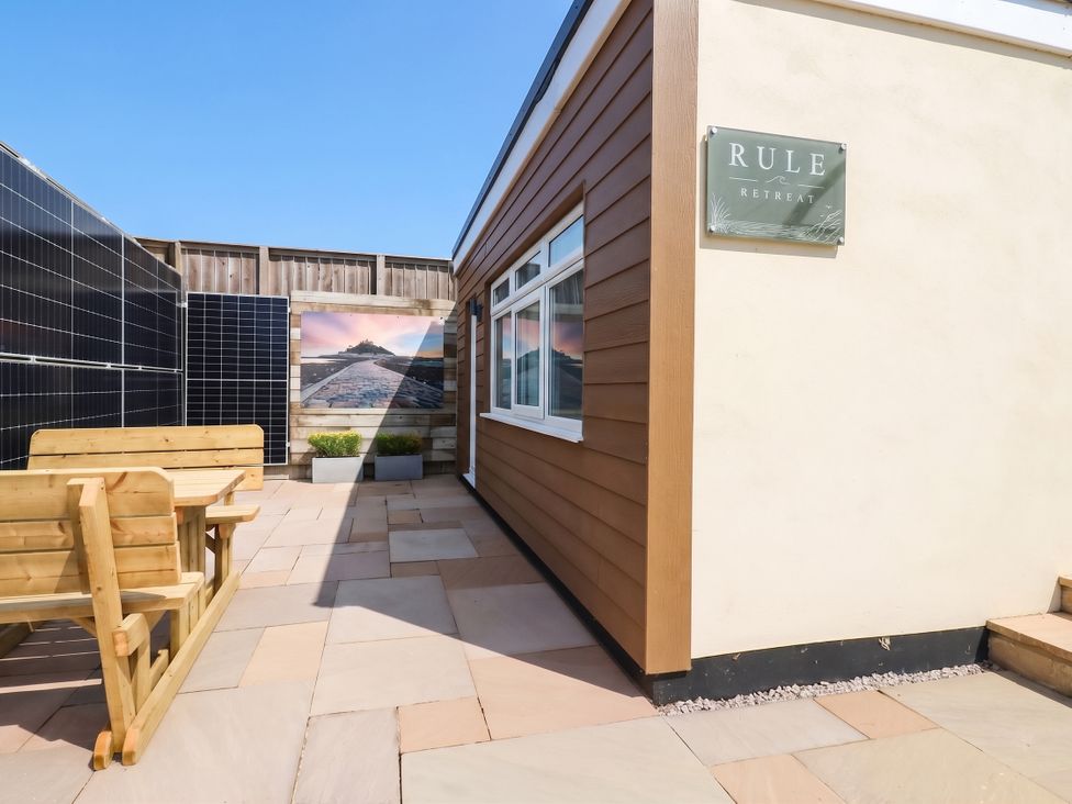 An outdoor area with seating and solar panels at Rule Retreat in Penzance