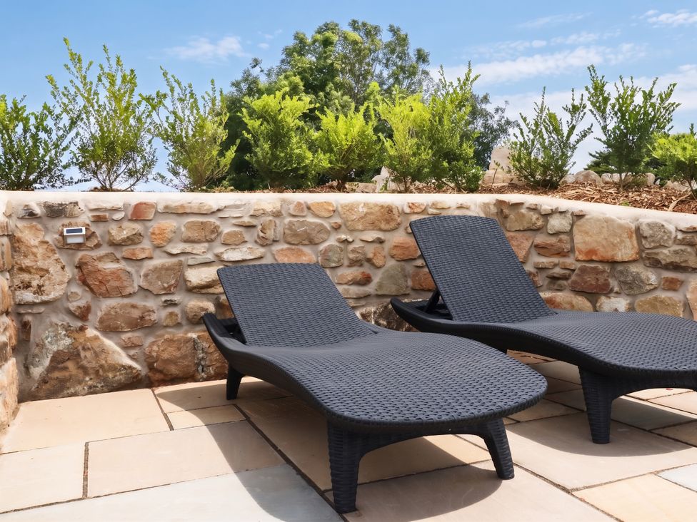 Two sun loungers near a stone wall in an outdoor area at Rule retreat in Penzance