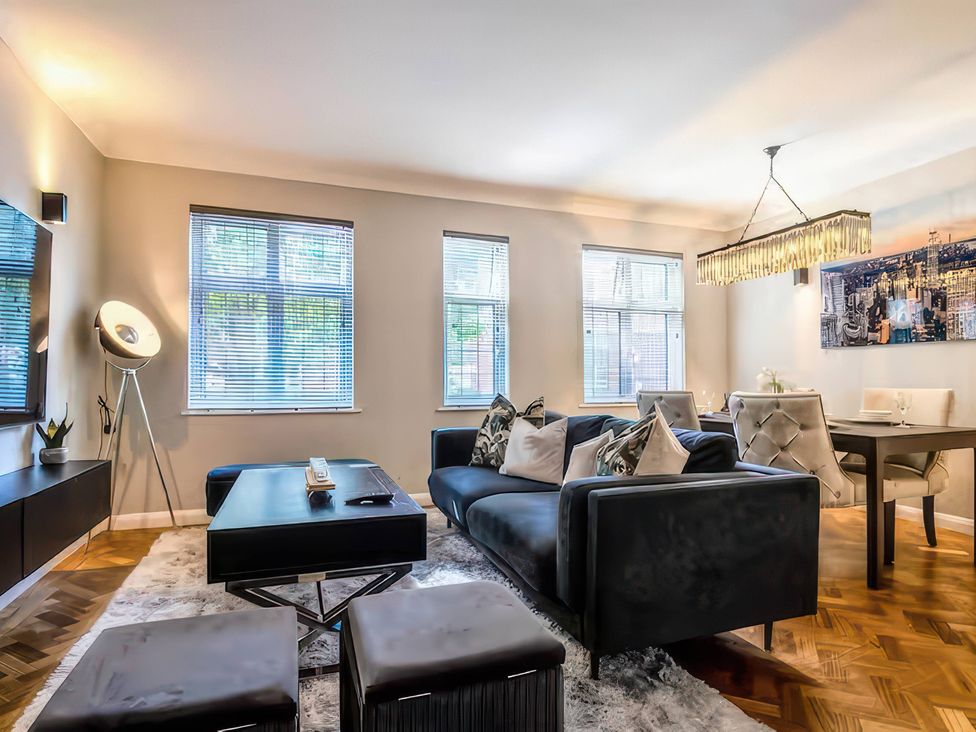 A living room with a sofa, coffee table, and dining area at 7 Wolsey Mansions Northwood, Hertfordshire