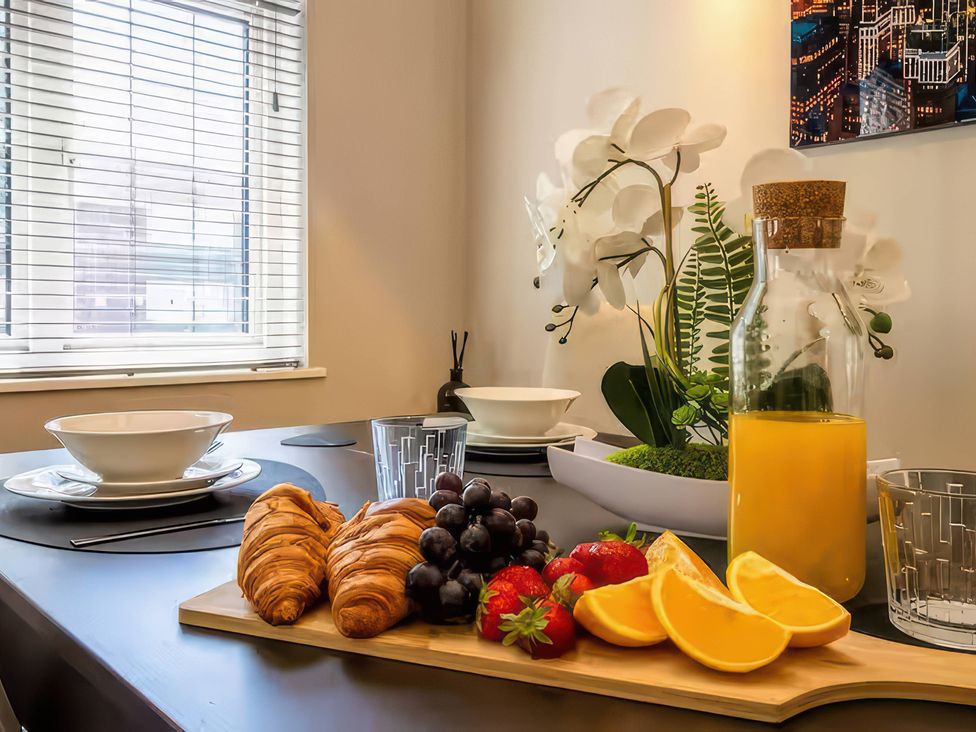 A dining table with food and drinks at 7 Wolsey Mansions in Northwood, Hertfordshire