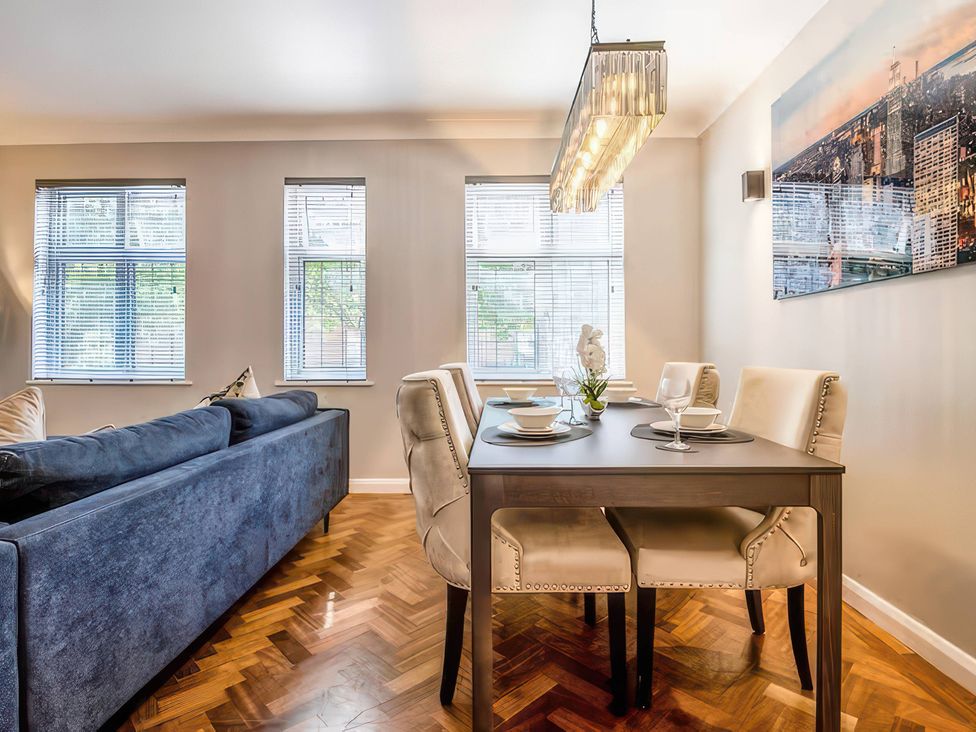 A dining room with a table and seating at 7 Wolsey Mansions in Northwood, Hertfordshire