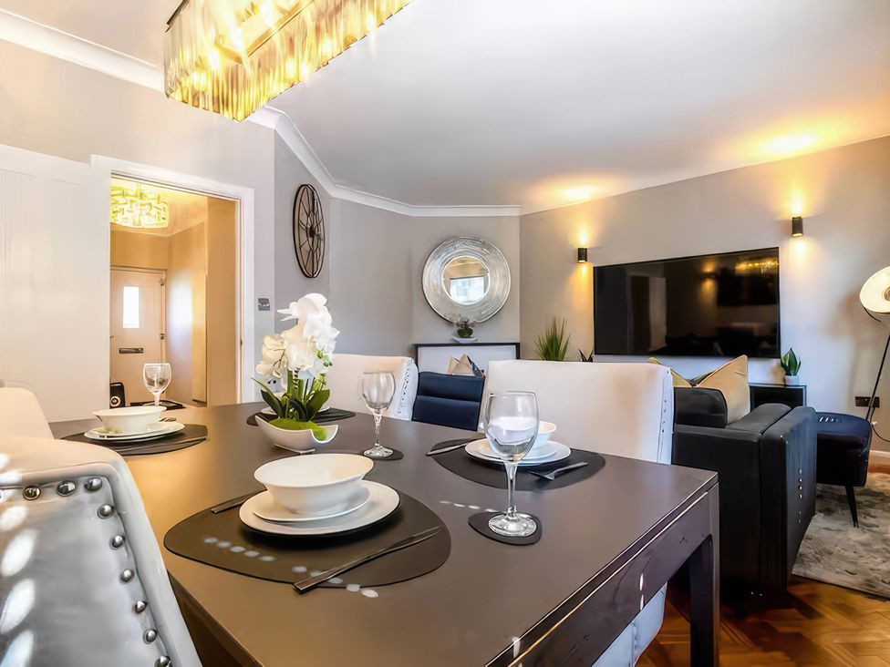 A dining area with a table and chairs at 7 Wolsey Mansions in Northwood, Hertfordshire