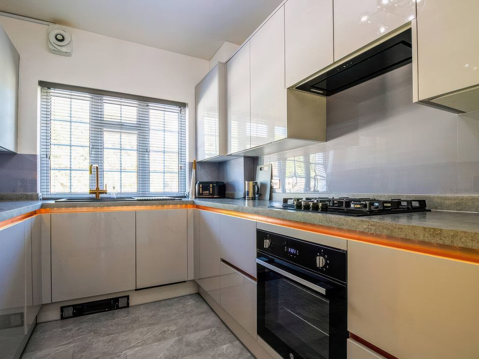 A kitchen with cabinets and appliances at 7 Wolsey Mansions in Northwood, Hertfordshire