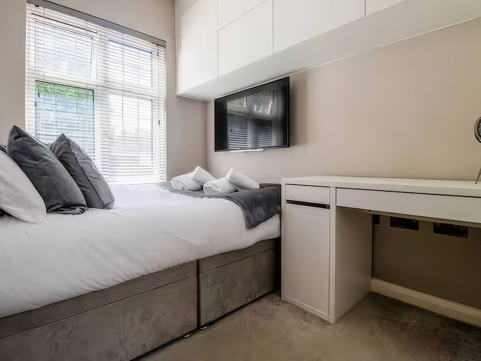 A bedroom with a bed and desk at 7 Wolsey Mansions Northwood, Hertfordshire