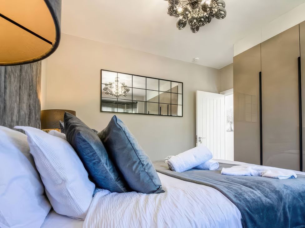 A bedroom with a bed and lamp at 7 Wolsey Mansions, Northwood, Hertfordshire
