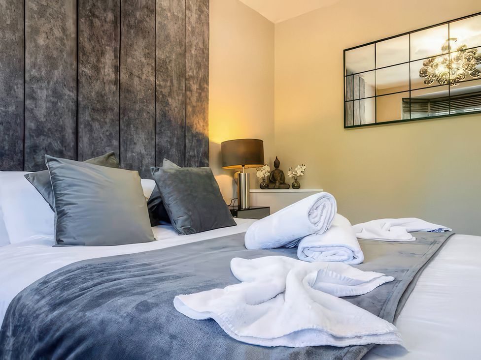 A bedroom with pillows and towels on the bed at 7 Wolsey Mansions Northwood, Hertfordshire