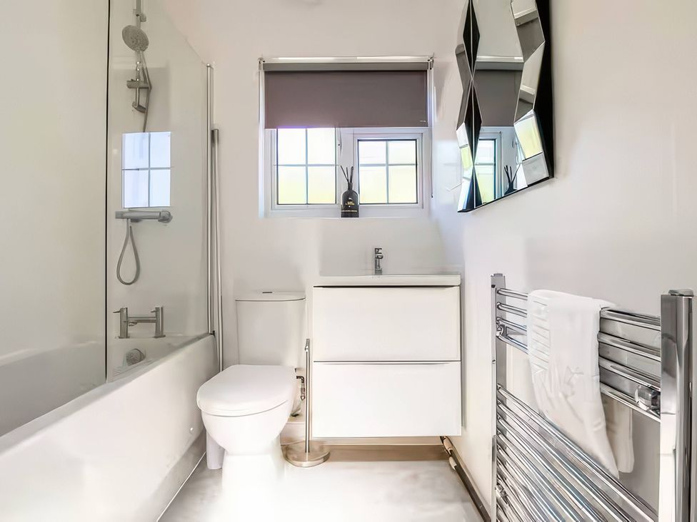 A bathroom with a bathtub, toilet, and sink at 7 Wolsey Mansions, Northwood, Hertfordshire