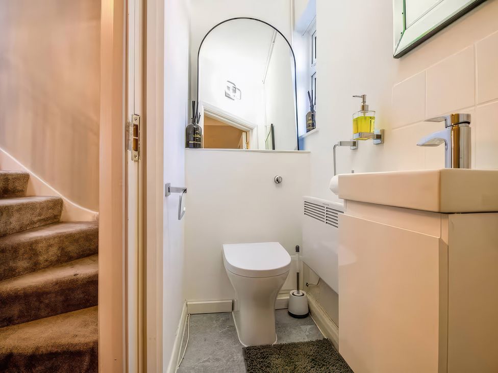 A bathroom with a toilet and sink at 7 Wolsey Mansions in Northwood, Hertfordshire