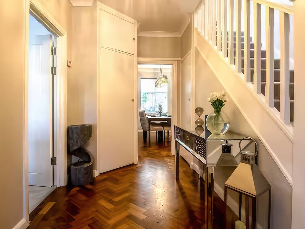 A hallway with a table and flowers at 7 Wolsey Mansions Northwood, Hertfordshire