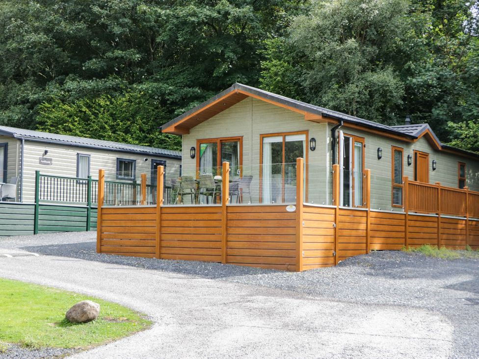 A log cabin with a deck and furniture at 19 Pony Meadow White Cross Bay near Troutbeck Bridge