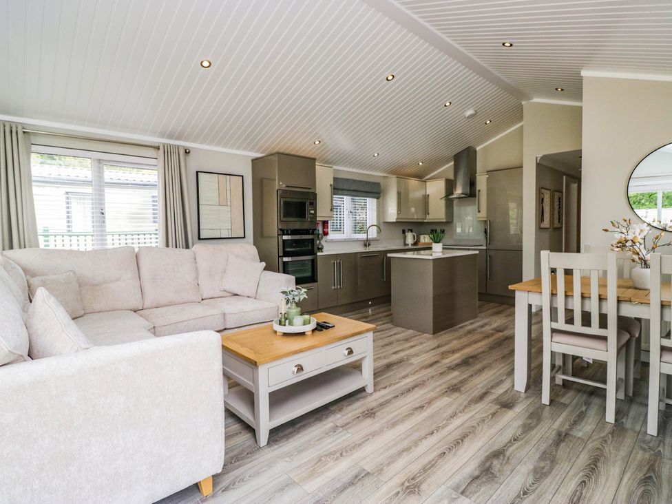 A kitchen with a sofa and dining table at 19 Pony Meadow near White Cross Bay